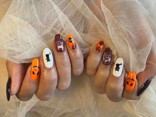 Nail art di Halloween arancio, nero e bianco
